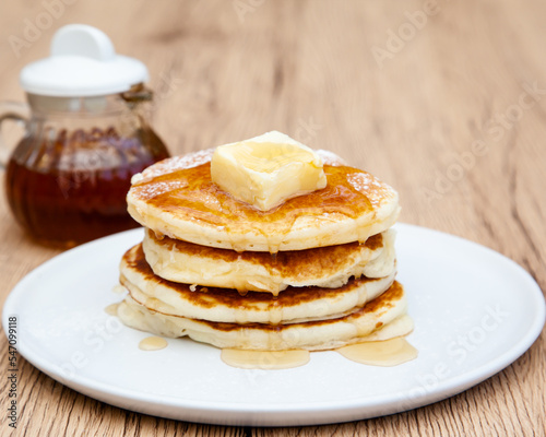 Stack of freshly made buttermilk pancakes with maple syrup and butter 