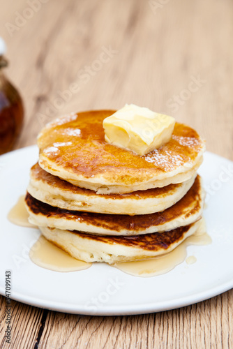 Stack of freshly made buttermilk pancakes with maple syrup and butter 