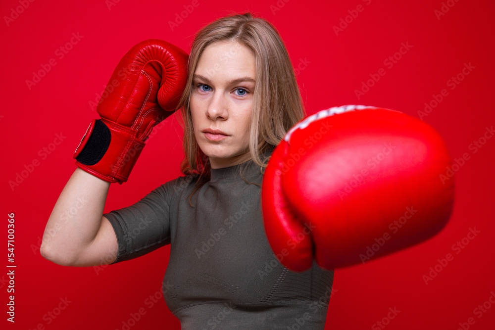Sporty young woman in red boxing gloves practicing punches Sporty young woman in red boxing gloves practicing punches