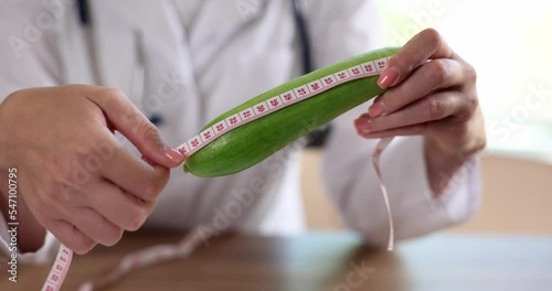 Urologist and andrologist measures cucumber with centimeter