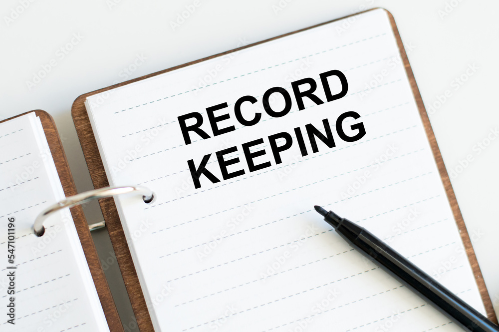 RECORD KEEPING text written on a notebook on the white background RECORD KEEPING text written on a notebook on the white background