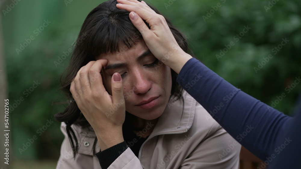 A sad hispanic woman having the support of empathic friend. Two latin women hugging each other in community A sad hispanic woman having the support of empathic friend. Two latin women hugging each other in community