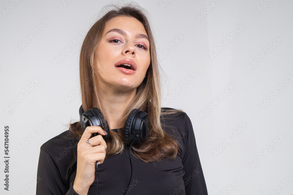 Beautiful brown-haired girl listens to music in big headphones