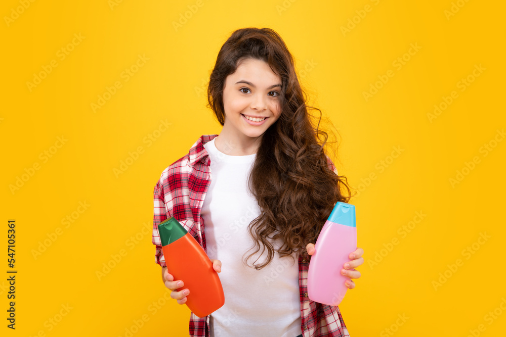 Teenager child girl with bottle shampoo conditioners or shower gel. Kids hair care. Hair cosmetic product, shampoo bottle. Happy teenager, positive and smiling emotions of teen girl. Teenager child girl with bottle shampoo conditioners or shower gel. Kids hair care. Hair cosmetic product, shampoo bottle. Happy teenager, positive and smiling emotions of teen girl.