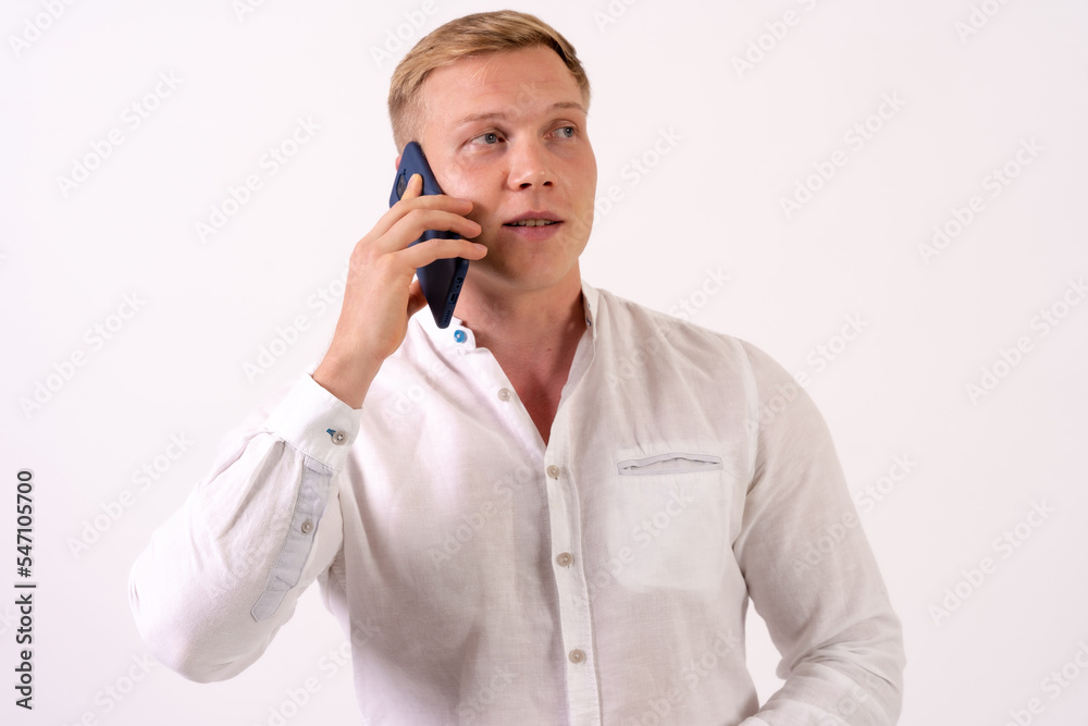 Caucasian blond businessman man making a work call with the phone on a white background Caucasian blond businessman man making a work call with the phone on a white background