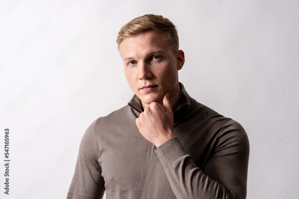 Portrait of a blond caucasian man with a brown sweater on a white background, looking at the camera Portrait of a blond caucasian man with a brown sweater on a white background, looking at the camera