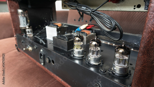 handcrafted brown leather covered amp head in the background 6l6 power lamp 12ax7 sound lamps audio output power inputs and spring loaded reverb tank