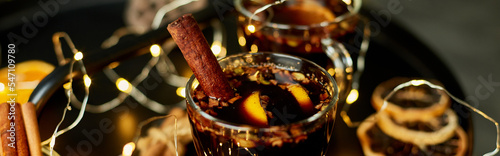 Fotografía Banner Christmas mulled red wine with spices and oranges on a black table with l