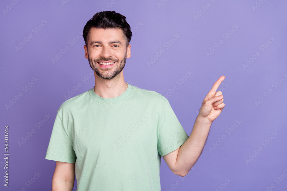 Close up photo of positive man dressed stylish clothes satisfied low price arm direct empty space isolated on purple color background Close up photo of positive man dressed stylish clothes satisfied low price arm direct empty space isolated on purple color background