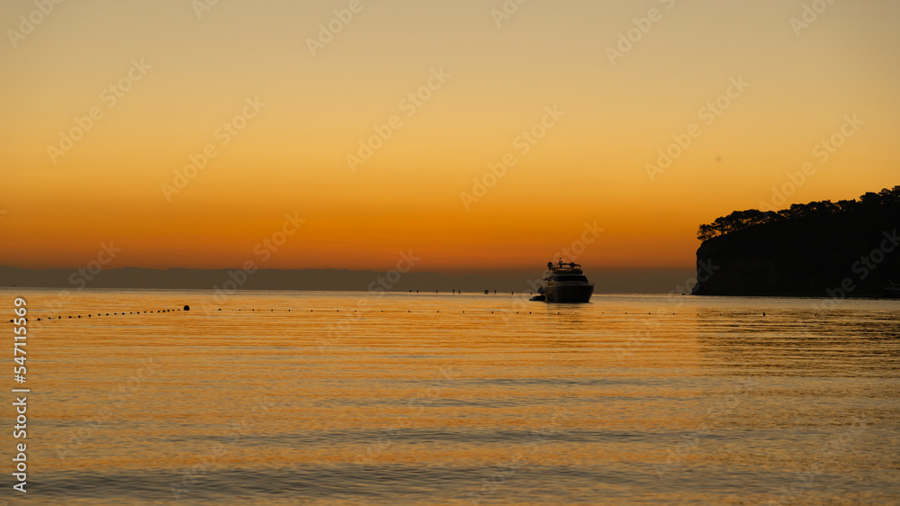 Orange dawn at sea, yacht at sea