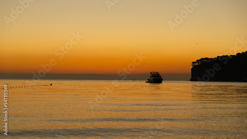 Orange dawn at sea, yacht at sea