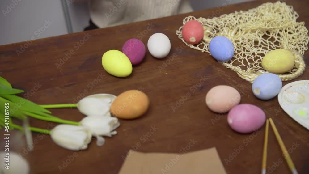 Close-up on a table with items to create a composition for Easter. Women's hands put Easter eggs on the table. Church holiday-Easter Close-up on a table with items to create a composition for Easter. Women's hands put Easter eggs on the table. Church holiday-Easter