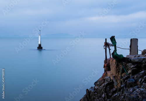 Concrete post in the sea off Waterfall Bay Park, Hong Kong Island probably for mooring or navigation. Long exposure gives the sea a smooth surface. Cliff top in the foreground.