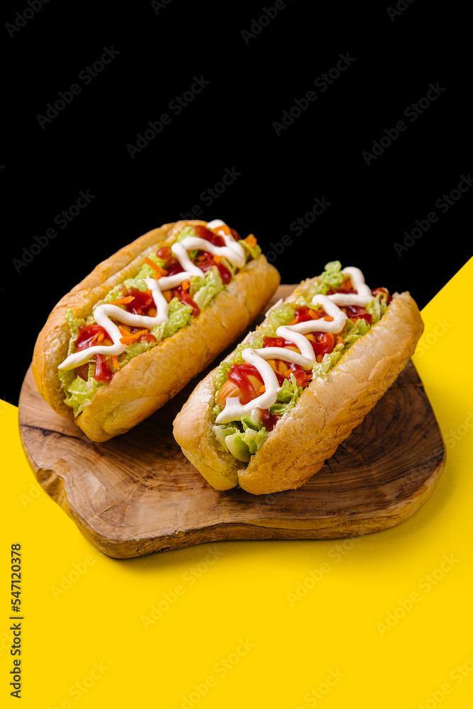 Two delicious hotdogs on wooden board Two delicious hotdogs on wooden board