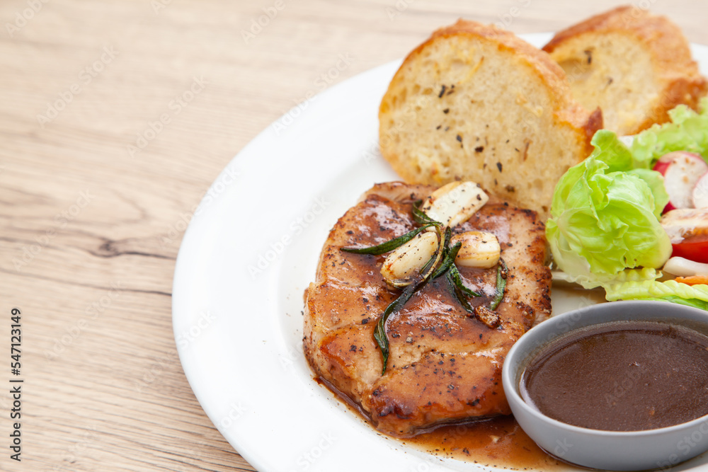 Pork sirloin steak with gravy sauce, salad and garlic bread Pork sirloin steak with gravy sauce, salad and garlic bread
