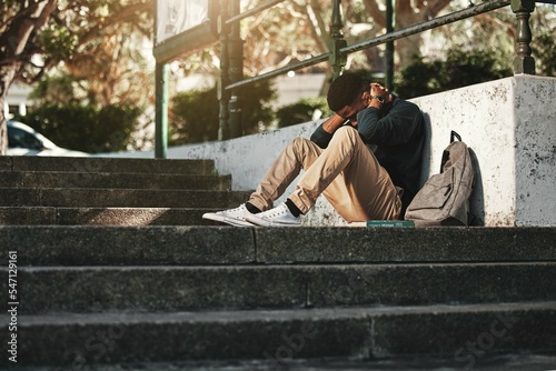 Sad, depression and black man with anxiety at college, stress and headache from education on the stairs at campus Fototapeta