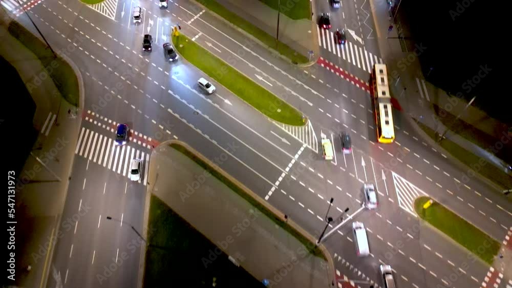 Low flying aerial tilting  shot of multi lane road in modern city center with skyscrapers at night