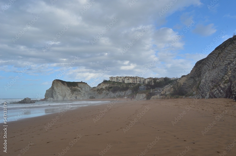 Playa del municipio de sopelana con Edificios en los acantilados y cielo azul con nubes