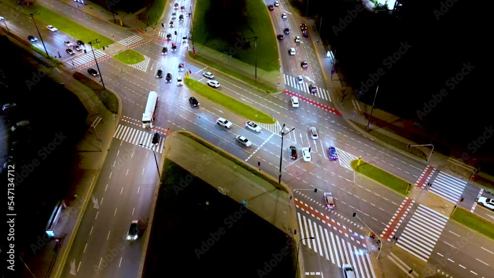 Low flying aerial tilting  shot of multi lane road in modern city center with skyscrapers at night