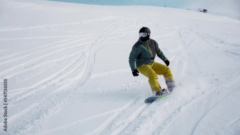 Snowboarder making turns in the powder snow during winter Snowboarder making turns in the powder snow during winter