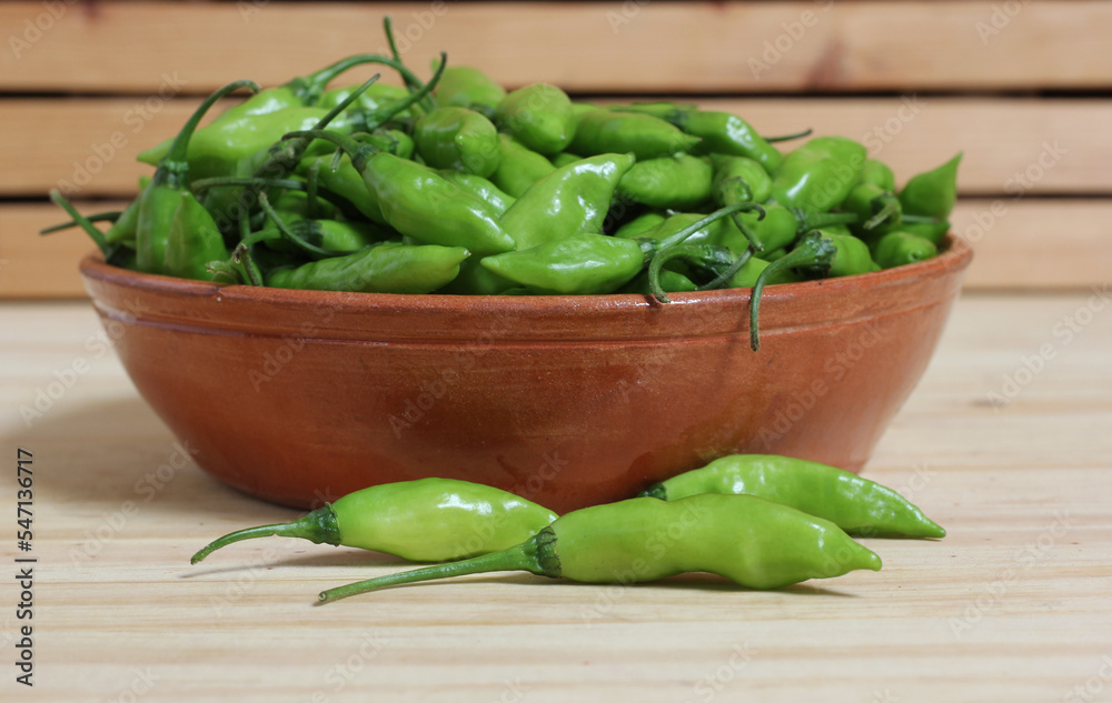 Bowl of Fresh Green Aji Limo Chili Peppers on Wooden Table Bowl of Fresh Green Aji Limo Chili Peppers on Wooden Table
