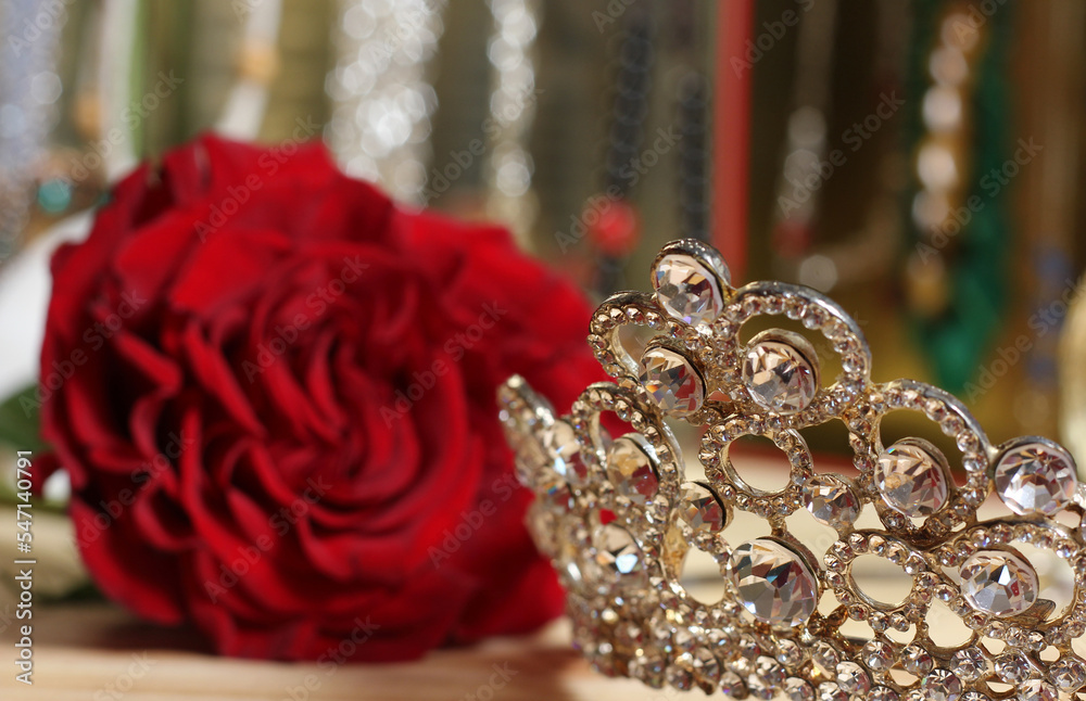 Rose and Tiara with Perfume and Jewelry in Background Rose and Tiara with Perfume and Jewelry in Background