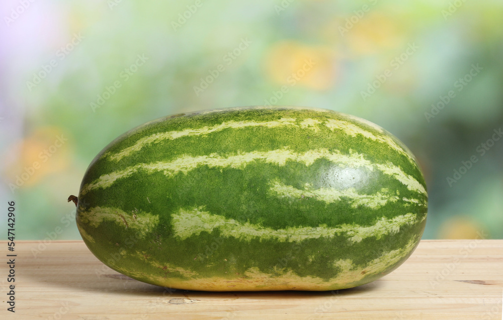Fresh Watermelon on Wooden Table With Green Nature Blur Background Fresh Watermelon on Wooden Table With Green Nature Blur Background