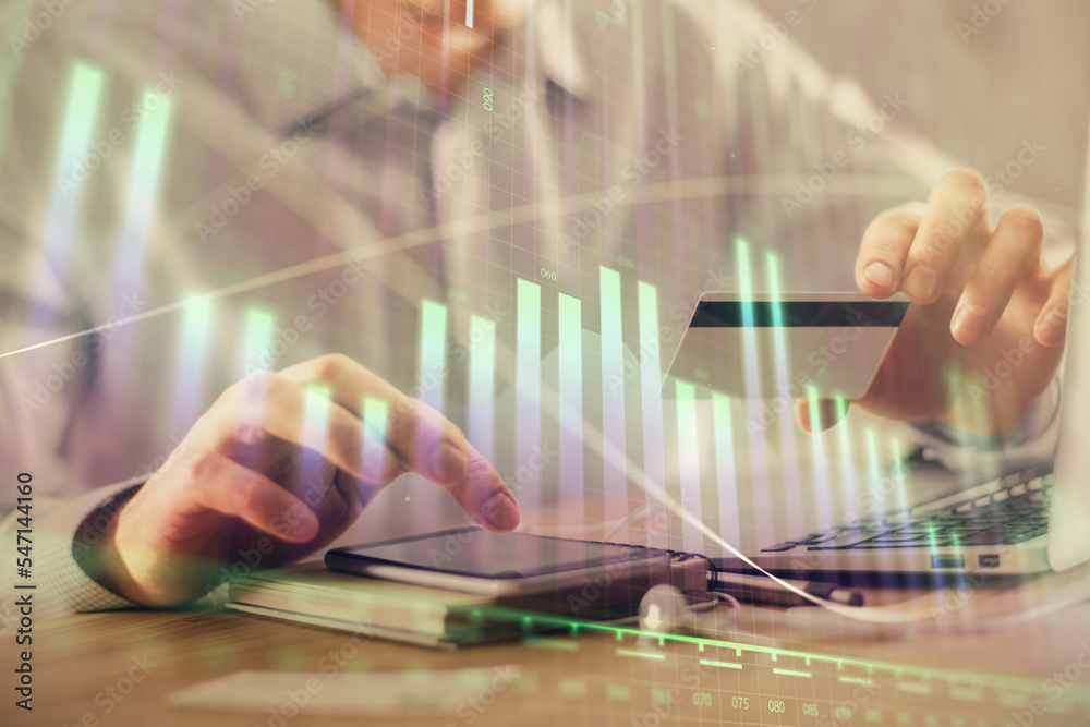 Double exposure of man hands holding a credit card and Forex graph drawing. Stock trading and digital fintech in Internet E-commerce concept.