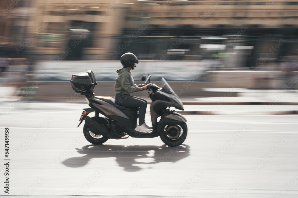Person driving a three wheels scooter in the city