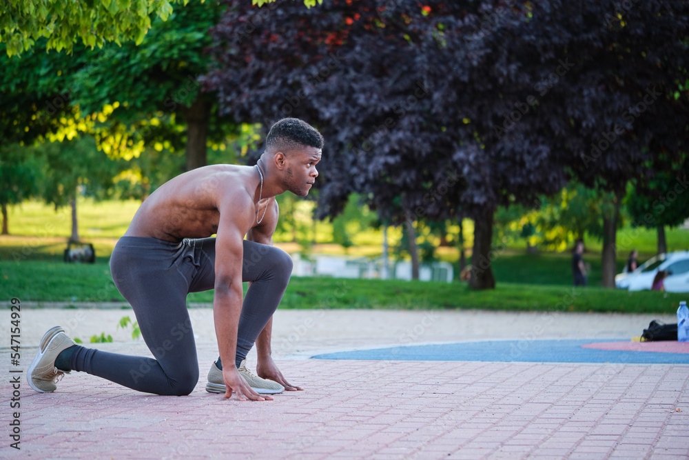 Fototapeta premium Young fit shirtless black man ready to run outdoors on sunny summer day. Fitness and sport lifestyle.