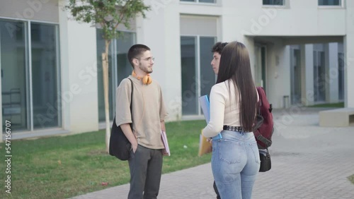 a group of college students at the university campus talking about exams.