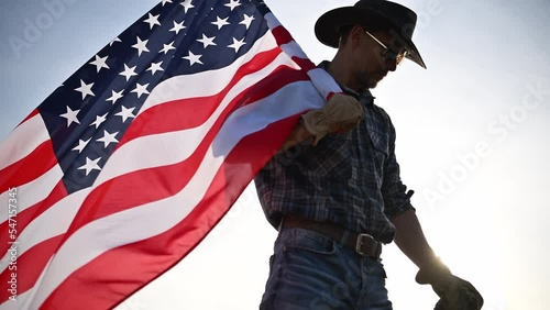 American Caucasian Cowboy in His 40s Waving United States Flag. Proud Patriot. photo