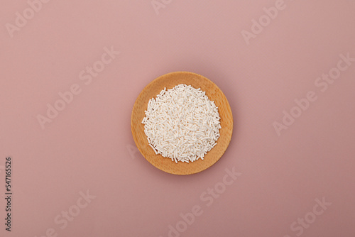 Potassium sorbate, granular potassium salt of sorbic acid in wooden plate, top view. Food additive E202 used in variety of applications including food, wine, and personal-care products photo