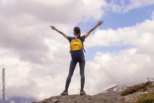 Woman stands on mountain top raised his hands pure nature enjoying the landscape