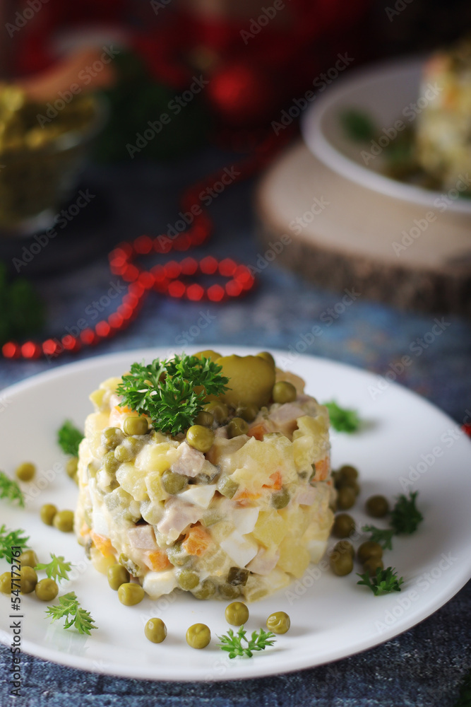 Olivier salad, traditional Russian dish, served on the plate for New Year dinner Olivier salad, traditional Russian dish, served on the plate for New Year dinner