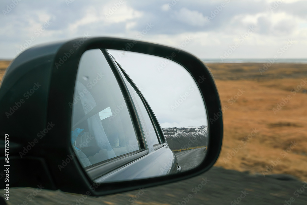 Naklejka premium Rear view mirror with mountain road by winter