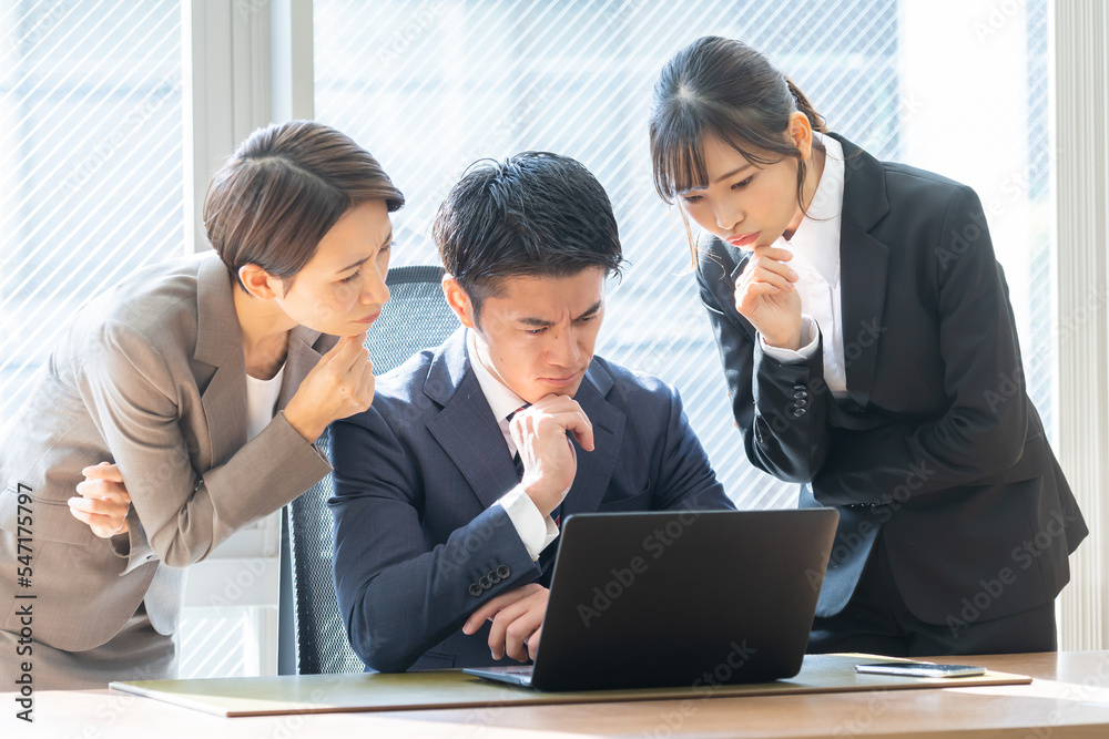 考えるスーツを着た日本人男性