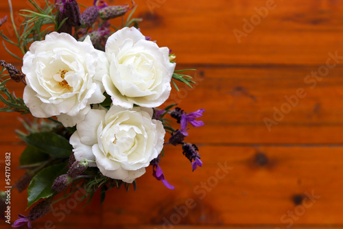 Natural white flowers bouquet in wooden background © Martha