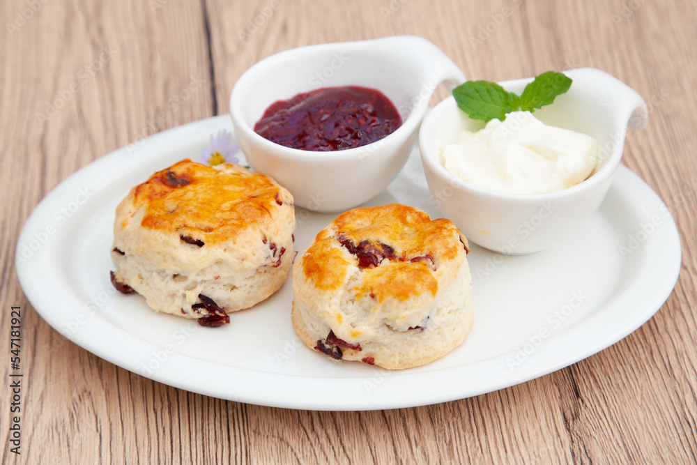 Cranberry scone set with raspberry jam and clotted cream Cranberry scone set with raspberry jam and clotted cream
