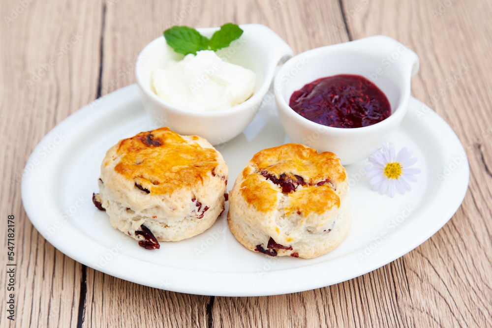 Cranberry scone set with raspberry jam and clotted cream Cranberry scone set with raspberry jam and clotted cream