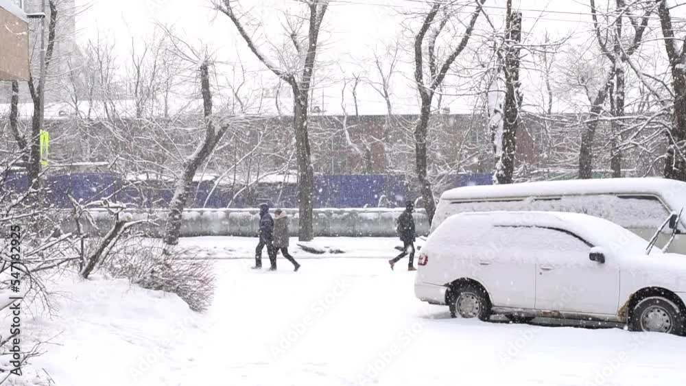 Winter, 2020 - Vladivostok, Russia - Winter in Vladivostok. Slow motion. People walk down the street during a heavy snowfall. Winter, 2020 - Vladivostok, Russia - Winter in Vladivostok. Slow motion. People walk down the street during a heavy snowfall.
