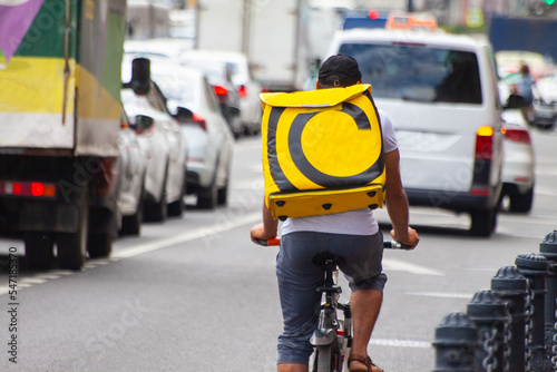 Wallpaper Mural Velo courier with a yellow backpack delivers goods in the city in summer Torontodigital.ca