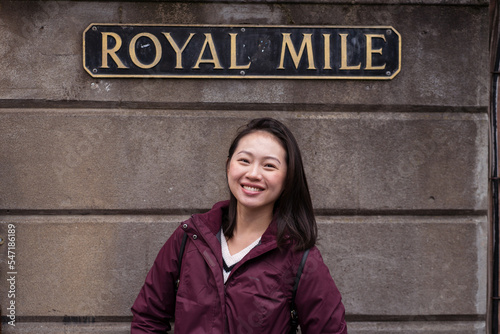 Happy Asian woman under Royal Mile sign photo
