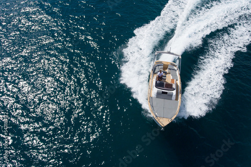 Drone top view of a small luxury boat sailing at high speed