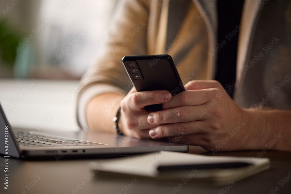 Close Up Of Man Using Mobile Phone At Desk Using App Or Searching Social Media