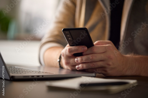 Close Up Of Man Using Mobile Phone At Desk Using App Or Searching Social Media