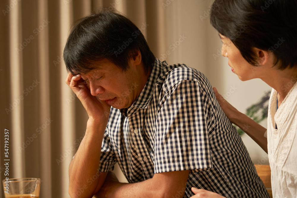 家で落ち込む中年男性 家で落ち込む中年男性