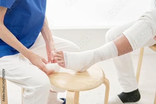 Fotografie, Obraz 患者の足首に包帯を巻く看護師　顔無し