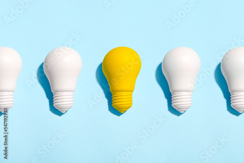 light bulb success business ideas creativity and inspiration concepts on blue background. Goal achievements flat lay minimalist composition