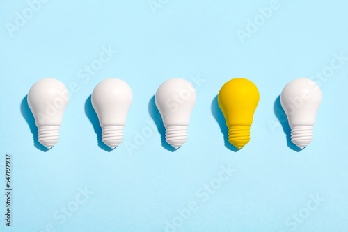 light bulb success business ideas creativity and inspiration concepts on blue background. Goal achievements flat lay minimalist composition